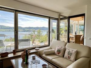a living room with a couch and large windows at Holiday Home Seepanorama by Interhome in Wangen +52 photos