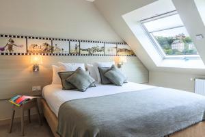a bedroom with a large bed with a window at Best Western Les Bains Hotel et SPA in Perros-Guirec
