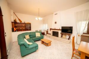 a living room with a green couch and a television at La Casa dei Ricordi in Monopoli