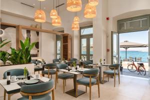 a restaurant with tables and chairs and a view of the ocean at YeeOn Living-Well Boutique City Hotel Gythio in Gythio