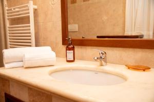 a bathroom sink with a bottle of alcohol on it at La Casa dei Ricordi in Monopoli +36 photos