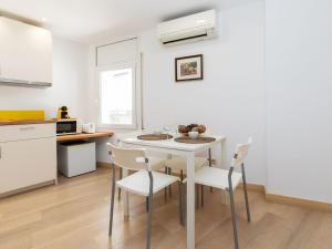 a kitchen and dining room with a white table and chairs at Apartment Marinada by Interhome in Tossa de Mar