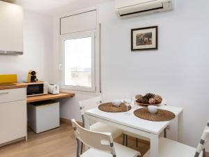 a kitchen and dining room with a white table and chairs at Apartment Marinada by Interhome in Tossa de Mar