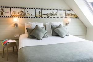 a bedroom with a large white bed with pillows at Best Western Les Bains Hotel et SPA in Perros-Guirec