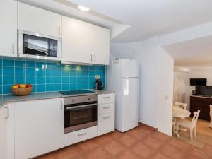 a kitchen with white cabinets and a refrigerator at Apartment Gregal by Interhome in Tossa de Mar