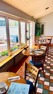 a restaurant with wooden tables and chairs and windows at An Cruiscin Lan in Spiddal
