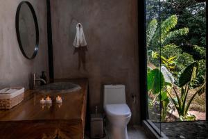 a bathroom with a toilet and a sink and a mirror at El Indio EcoLodge in El Amparo +14 photos