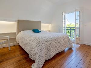 a bedroom with a bed with a blue pillow on it at Holiday Home Villa Deauville by Interhome in Deauville