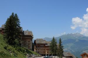 a building on the side of a hill with a mountain at Résidence Goélia Les Chalets de Wengen in Les Coches