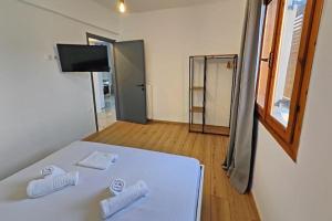 a bedroom with a white bed with two pillows on it at Village Villa, Agios Georgios Grevena in Grevena