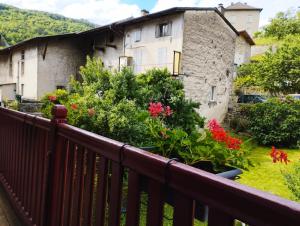 a balcony of an old house with flowers at gîte Couleur Cuivre in Cerdon