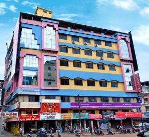 a large building with many windows on a street at Hotel Durga International in Udupi