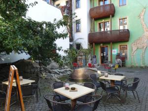 ein Restaurant mit Tischen und Stühlen vor einem Gebäude in der Unterkunft Neustadtperle in Dresden