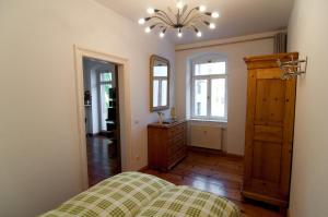 Schlafzimmer mit einem Bett, einer Kommode und einem Spiegel in der Unterkunft Neustadtperle in Dresden