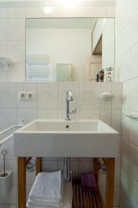 ein weißes Badezimmer mit Waschbecken und Spiegel in der Unterkunft Neustadtperle in Dresden + 16 Fotos