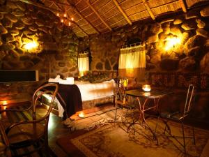 a bedroom with a bed and a table in a stone room at Tambo Coquesa Lodge in Coquesa