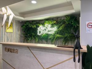 un bancone con un'insegna al neon su un muro di Bonjour Hotel a Taichung