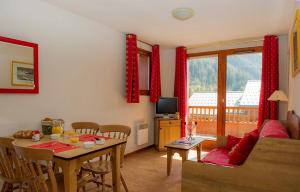 una sala de estar con una mesa y un sofá en Résidence Goélia Les Balcons d'Anaïs, en La Norma