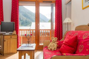 a teddy bear sitting on a couch in a living room at Résidence Goélia Les Balcons d'Anaïs in La Norma