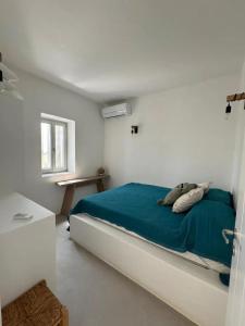 a bedroom with a bed with a blue blanket at Comfortable apartment with sea view in Antiparos, 77 m² in Andiparos +21 photos