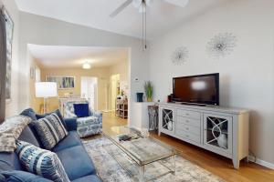 a living room with a blue couch and a flat screen tv at Windy Harbor House in Wilmington