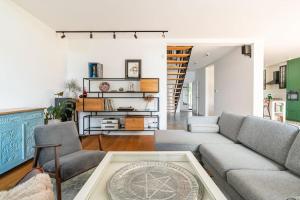 a living room with a couch and chairs and a staircase at Parkowa Garden in Michałowice