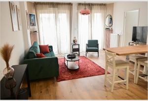 a living room with a green couch and a table at Appart charmant au cœur de la ville et des commodités in Saint-Ouen