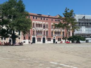 un gran edificio de ladrillo con árboles delante de él en Ca Francesca, en Venecia