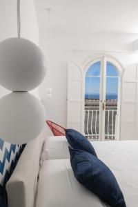 un soggiorno con divano bianco e finestra di La Maison De La Ville a Massa Lubrense