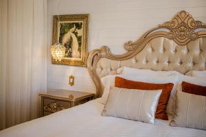 a bedroom with a large white bed and a picture on the wall at Pousada Dom Pietro in Urubici