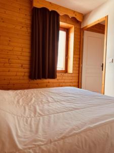 a bedroom with a bed and a window at Le Tétras Lyre Les Balcons de Recoin in Chamrousse