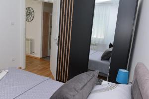 um espelho num quarto com 2 camas e um quarto em Apartman Luka em Kraljevo