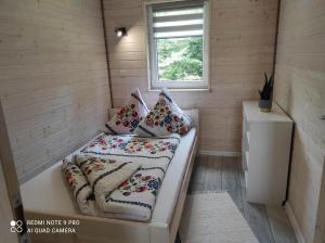 - une petite chambre avec un lit dans une petite maison dans l'établissement Domki na Górce, à Polańczyk