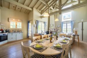 Una cocina y un comedor con mesa y sillas. en Unique Pool Villa 500m from the beach, Hamptons Style with beautiful Garden, en Moliets-et-Maa