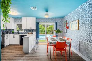a kitchen with a table and chairs and a kitchen with a pool at Eccentric home with pool tiki hut & outdoor kitchen in Pompano Beach