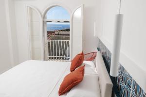 una stanza bianca con un letto e una finestra di La Maison De La Ville a Massa Lubrense