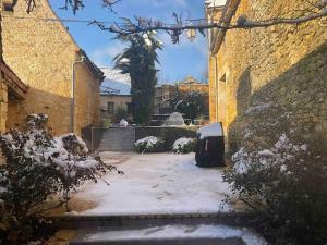 a courtyard covered in snow with a trash can at Le Clos de Peyruzel, Daglan in Daglan