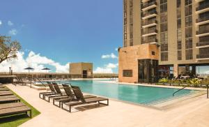 a swimming pool with chaise lounges and chairs at Flow Hotel Fort Lauderdale in Fort Lauderdale