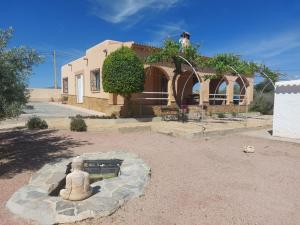 Eine Statue eines Mannes, der vor einem Haus sitzt. in der Unterkunft Cortijo de Fidel in Vera