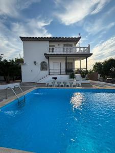 a villa with a swimming pool in front of a house at Los Ogíjares in Ogíjares