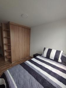 a bedroom with a bed and a wooden cabinet at Apartamento Ibagué in Ibagué