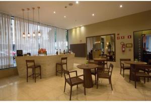 a restaurant with tables and chairs and a bar at Charmoso Duplex ao Lado da Torre de TV Brasília in Torto