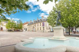 a statue of a woman on a fountain in a street at Cozy studio near RER B in Palaiseau