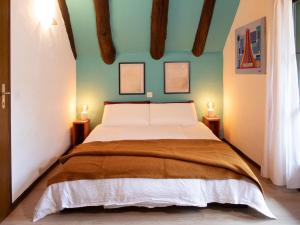 a bedroom with a large bed with two lamps at Verzasca Lodge Cassiopea in Frasco
