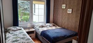 a small bedroom with a bed and a window at DOMKI KAJUTA in Żarnowska