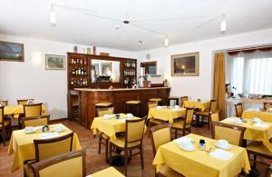 a restaurant with yellow tables and chairs with yellow table cloth at Hotel Gabarda in Carpi