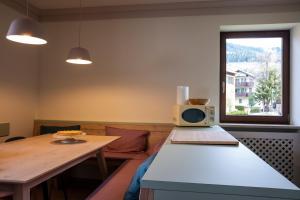 a room with a table with a microwave on it at Rosa Alpina - Appartamento nelle Dolomiti in Dobbiaco