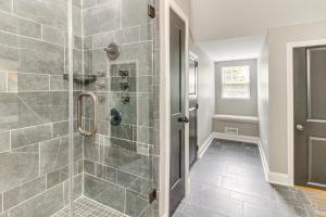 y baño con ducha de azulejos grises. en Charlotte Home with Yard - Near Spectrum Center!, en Charlotte 20 fotos más