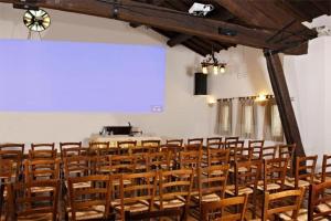 a room with a bunch of chairs and a screen at Hotel Gabarda in Carpi