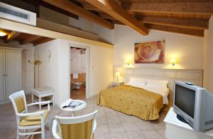 a bedroom with a bed and a tv and a table at Hotel Gabarda in Carpi
